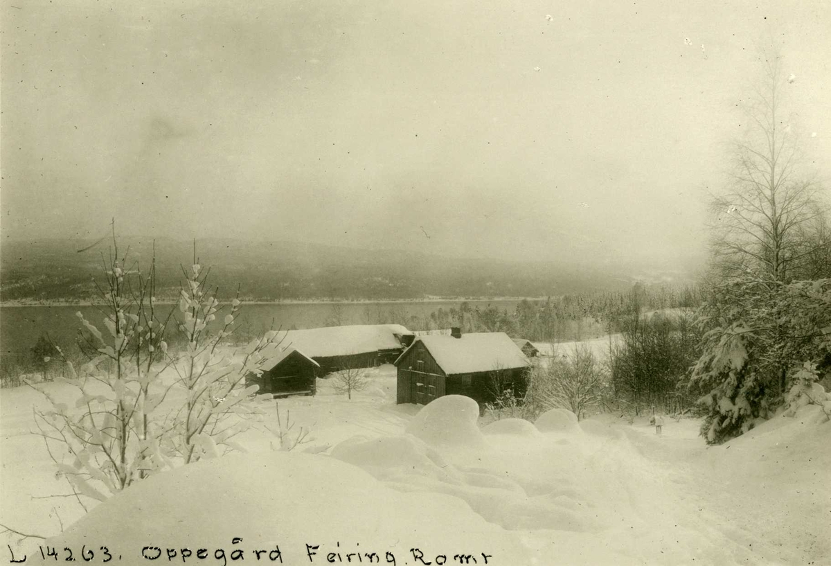 Oppegård, Feiring, Eidsvoll, Akershus. Vinterbilde av gård med mørke hus, sett fra oversiden med utsikt over Mjøsa. 