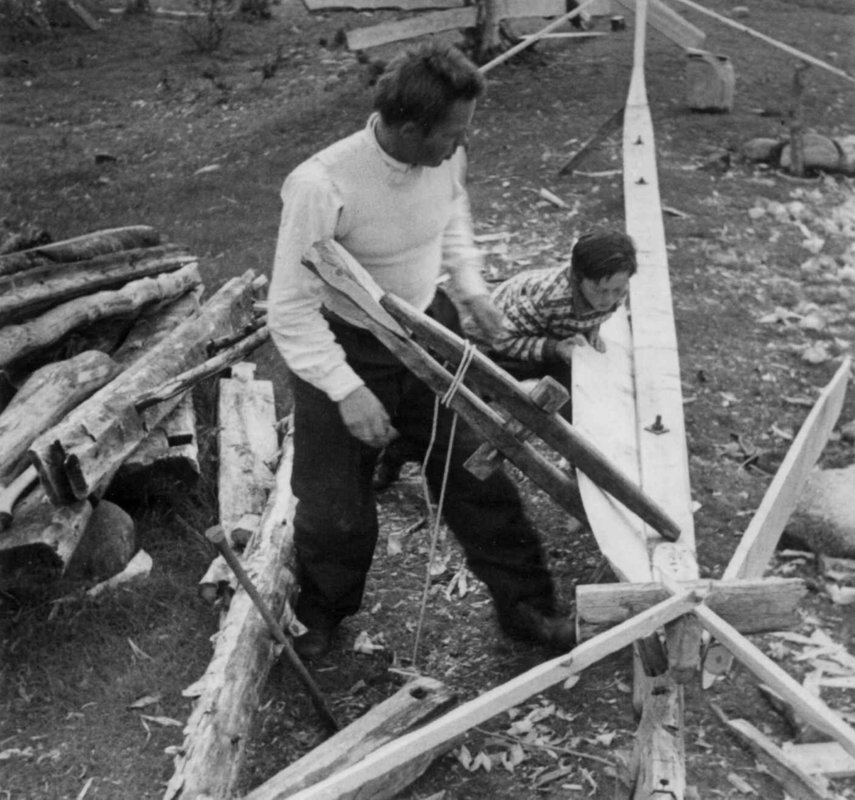 Alfred Rasmus Port bygger båt (5). En klemme settes over bordet for å få den rette vriing på det. Karasjok 1952.