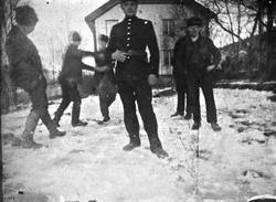 Gruppe menn og gutter morer seg på gårdstunet, Lunden gård, 