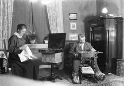 Mannen sitter og legger kabal med ant. skaller på bena og ko