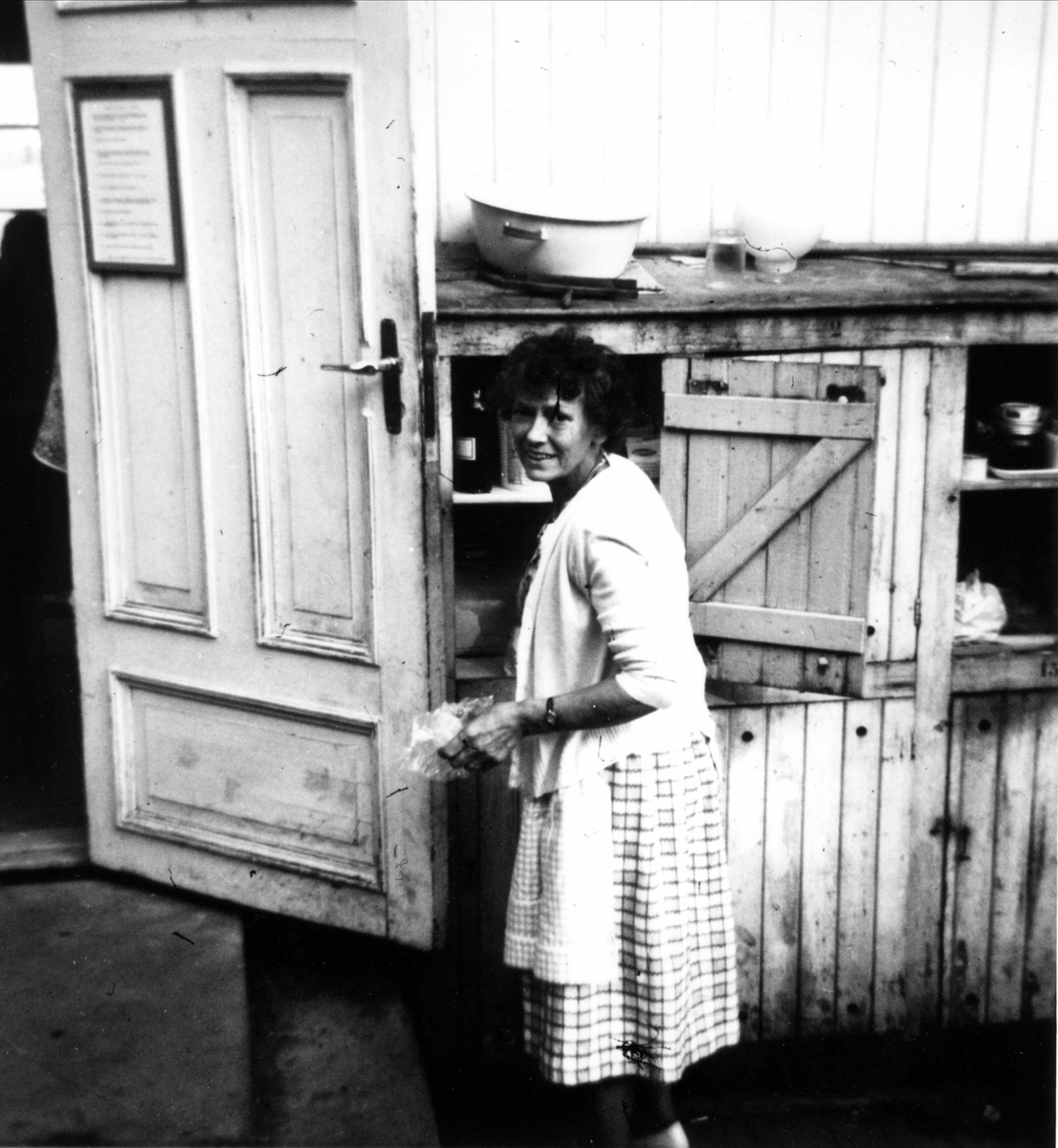 Kvinne ved uteskap i "Primusen" Oslo Godtemplarungdomslags feriehjem Kirkevik, Nesodden, ca 1964