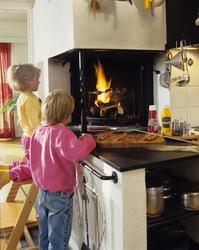 På kjøkkenet det en åpen peis med løs grillinnsats, to barn 