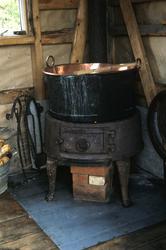 Inga Enodd fyrer i kjelringen i kokehuset på Endal seter.
K