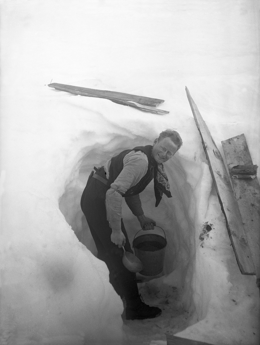 Ung mann, kalt Tot, henter vann i brønn, spadd ut i stor snøskavl. Fotografert påsken 1923.