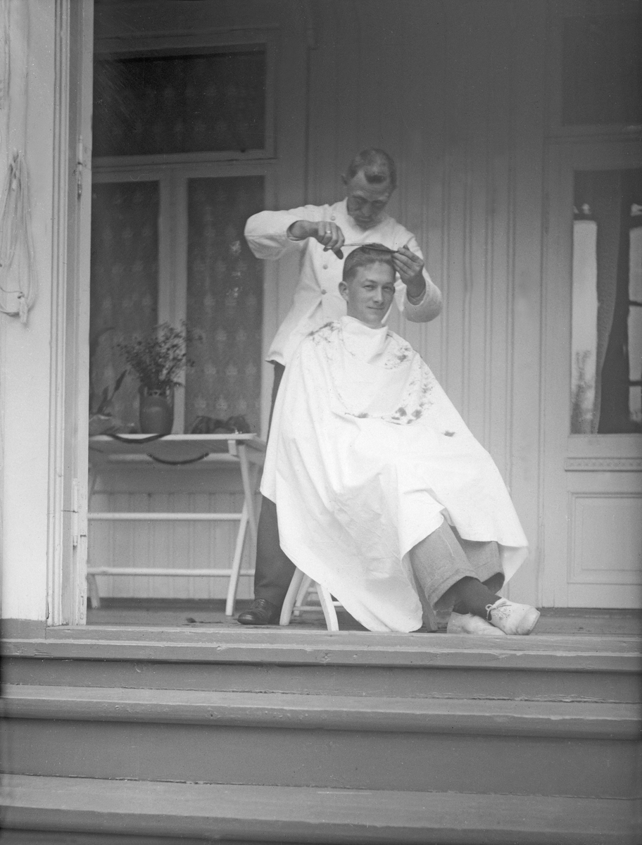Hårklipping på en veranda på Håøya ved Stokke i Vestfold. Fotografert 1923.