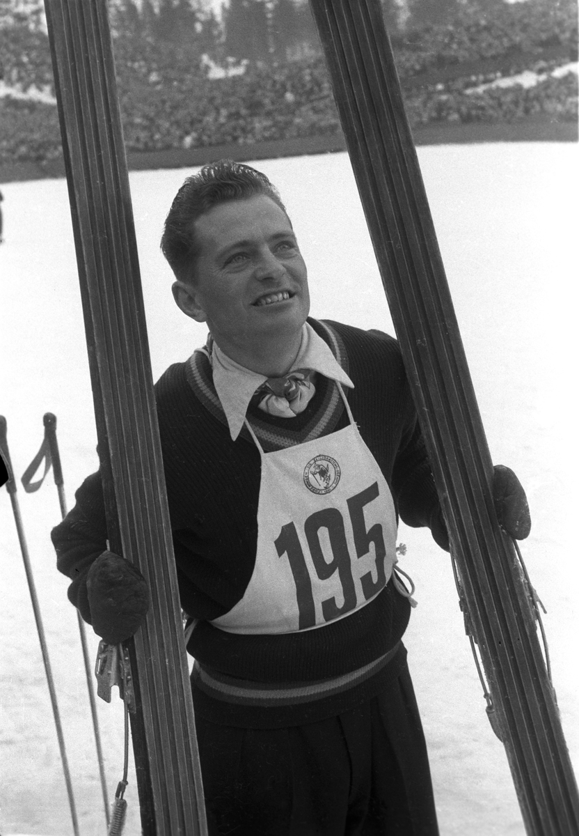 Hopper Arnfinn Bergmann med startnummer 195 nede på sletta. Publikum i bakgrunnen. Holmenkollhopp 1953. Fotograf Dagbladet