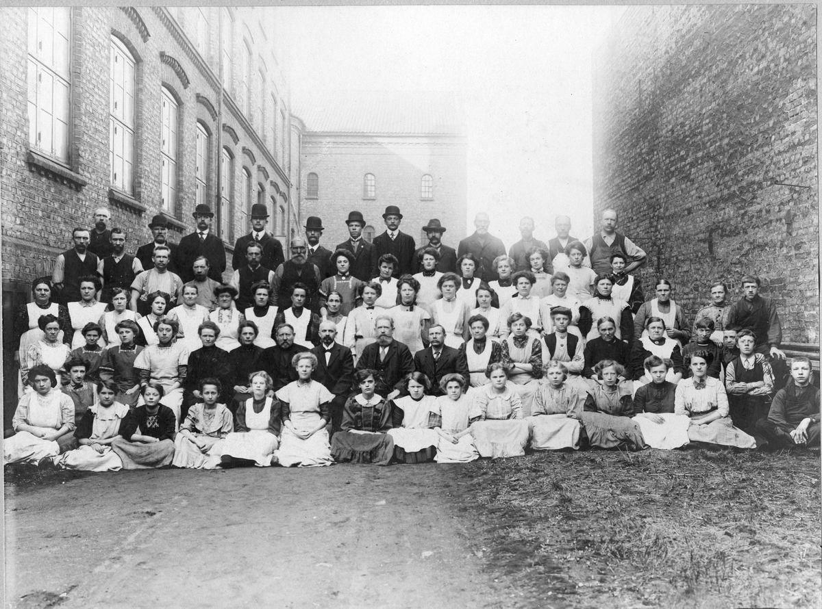 Gruppeportrett, fabrikkarbeidere fra Johannes N. Withs Tobaksfabrikker. Kvinner, menn og barn. Antatt før 1893.