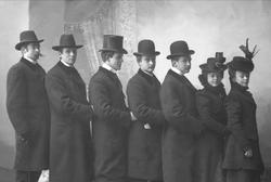 Gruppeportrett, fem herrer og to damer står på rekke etter h