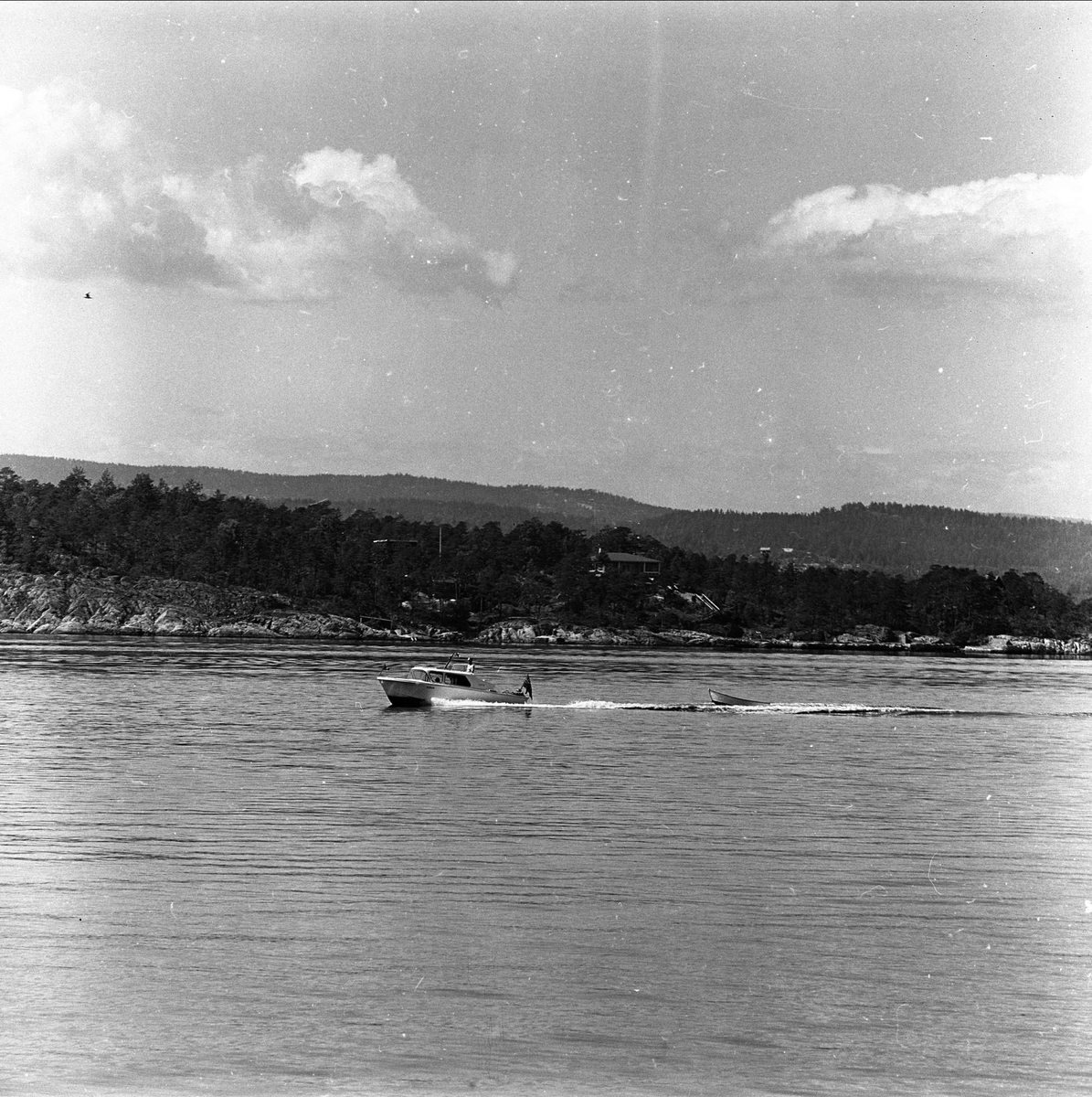 Nesodden, Akershus, 17.06.1961. Motorbåt med jolle på slep på sjøen.