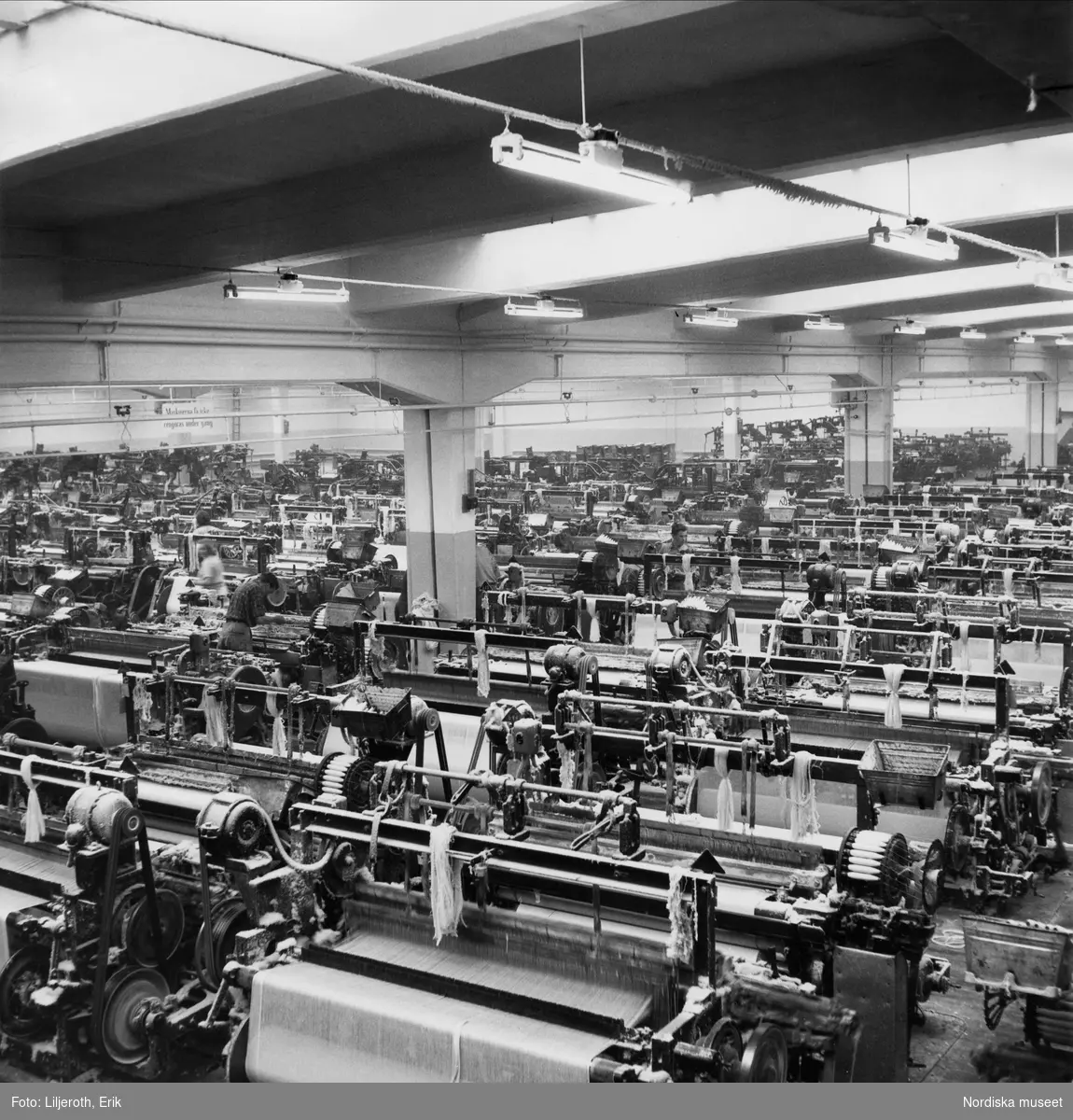 Arbetare och maskiner inne i Karlshams Yllefabrik i Åkersholm