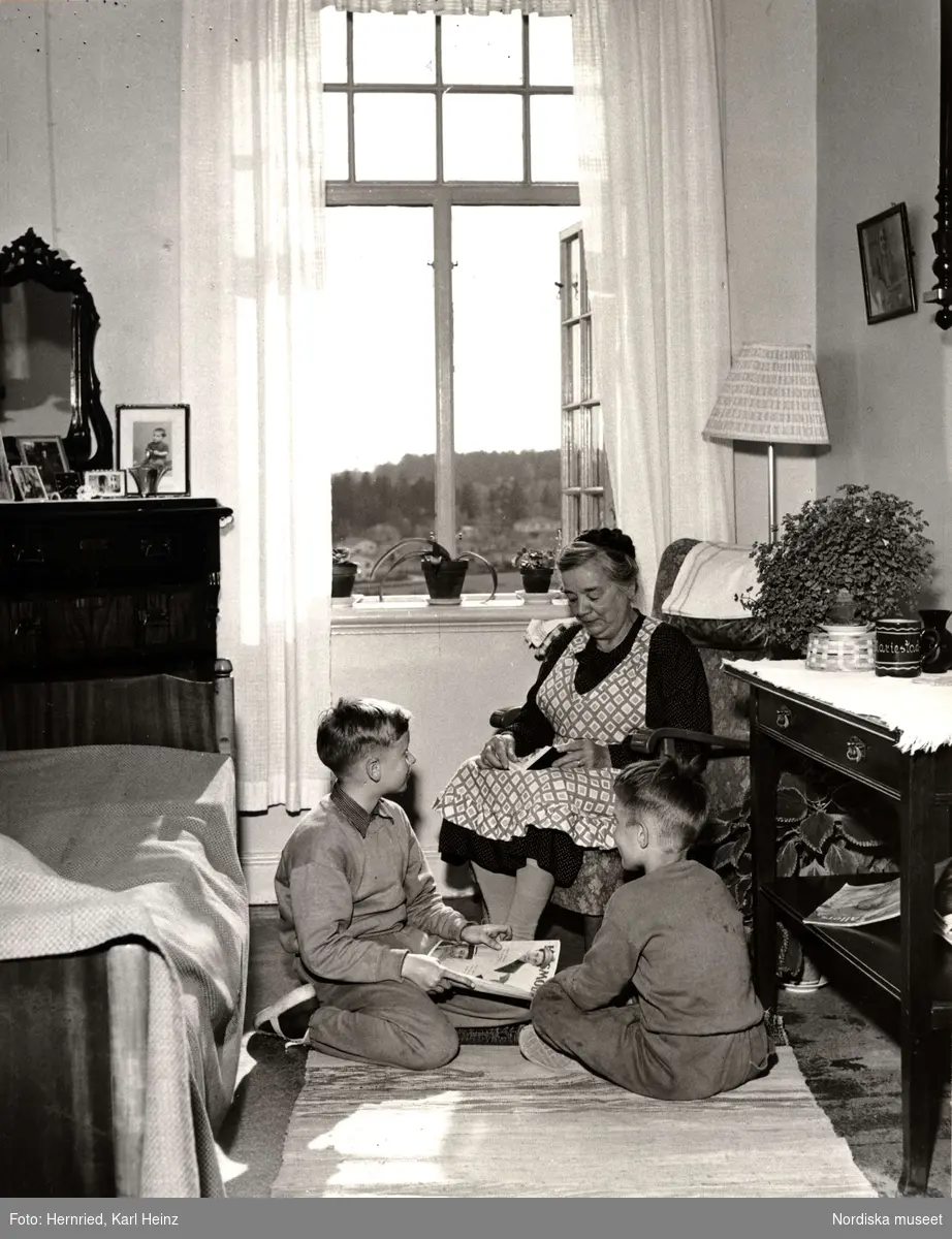 Fristad ålderdomshem i Spånga, Uppland. En kvinna och två pojkar sitter i ett rum och läser och samtalar