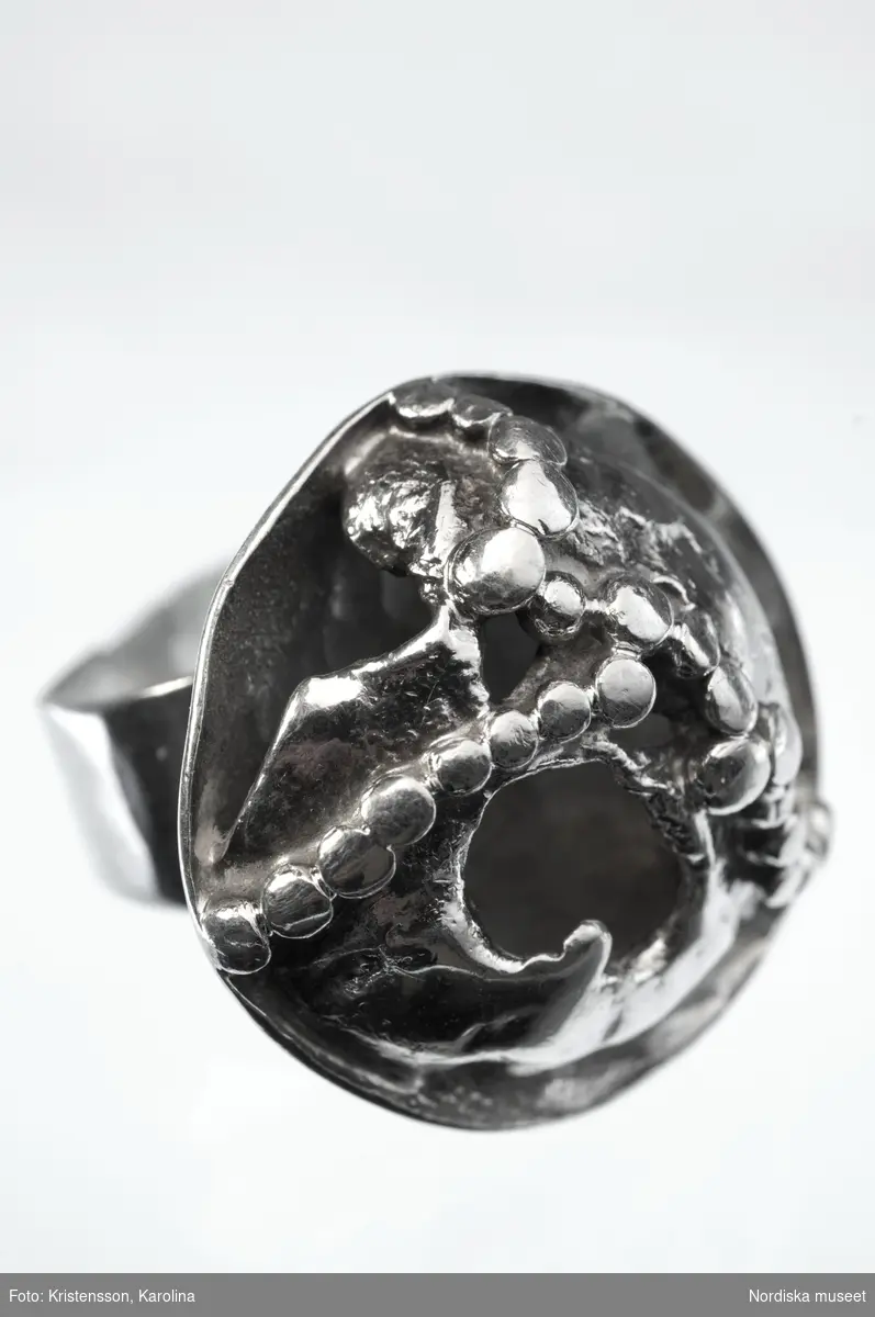 Ring tillhörande Margareta Persson, ringen är sannolikt ritad och utförd av Bernd Janusch, men stämplad med Rosa Taikons stämpel.
ring; silver; smycke; filigran-teknink