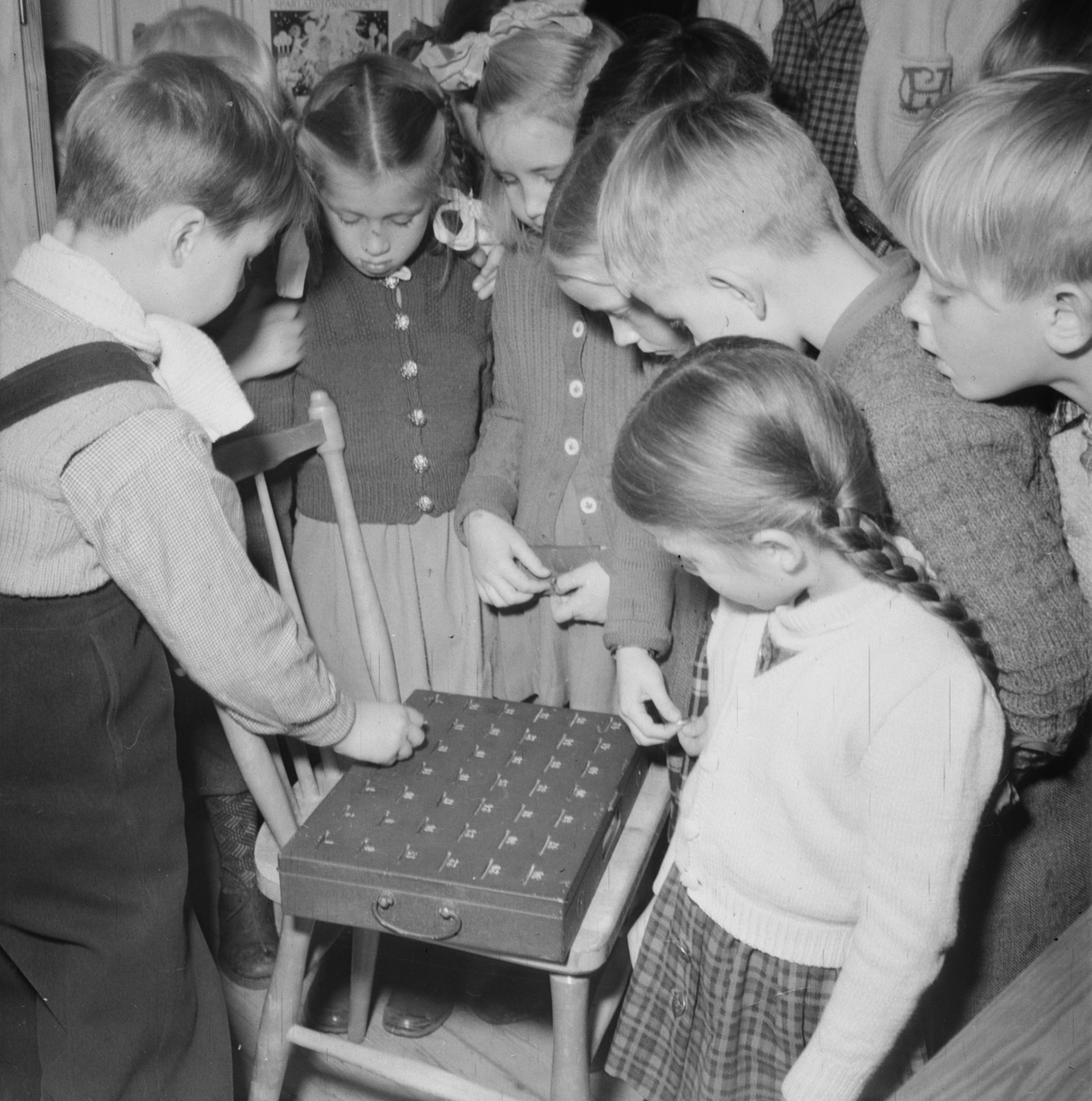 Flickor och pojkar tittar på en låda, Rådhuset, Uppsala 1947