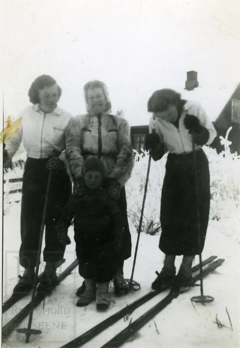 Vinterlandskap med tre kvinner og liten gutt.