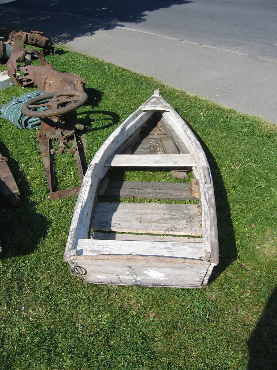 Flatbunnet liten åpen båt med akterspeil. Kravellbygd. Øverste bordgang, akterspeil og ripa er hvitmalt. Spiker som festemiddel.