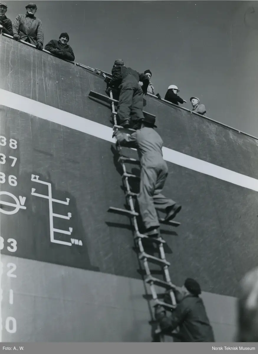 Arbeidere klatrer ombord på tankeren M/S Polarsol, B/N 522 (Stord Verfts B/N 43) under utrustning på Akers Mek. Verksted 7. mars 1960. Skipet ble levert av Akers Mek. Verksted og Stord Verft til A/S Polaris v/ Melsom & Melsom i 1960.