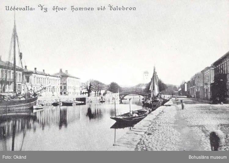 Tryckt text på kortet: "Uddevalla. Vy öfver hamnen vid Valvbron."
"Reproduktion av foto tillhörande Uddevalla Museum."