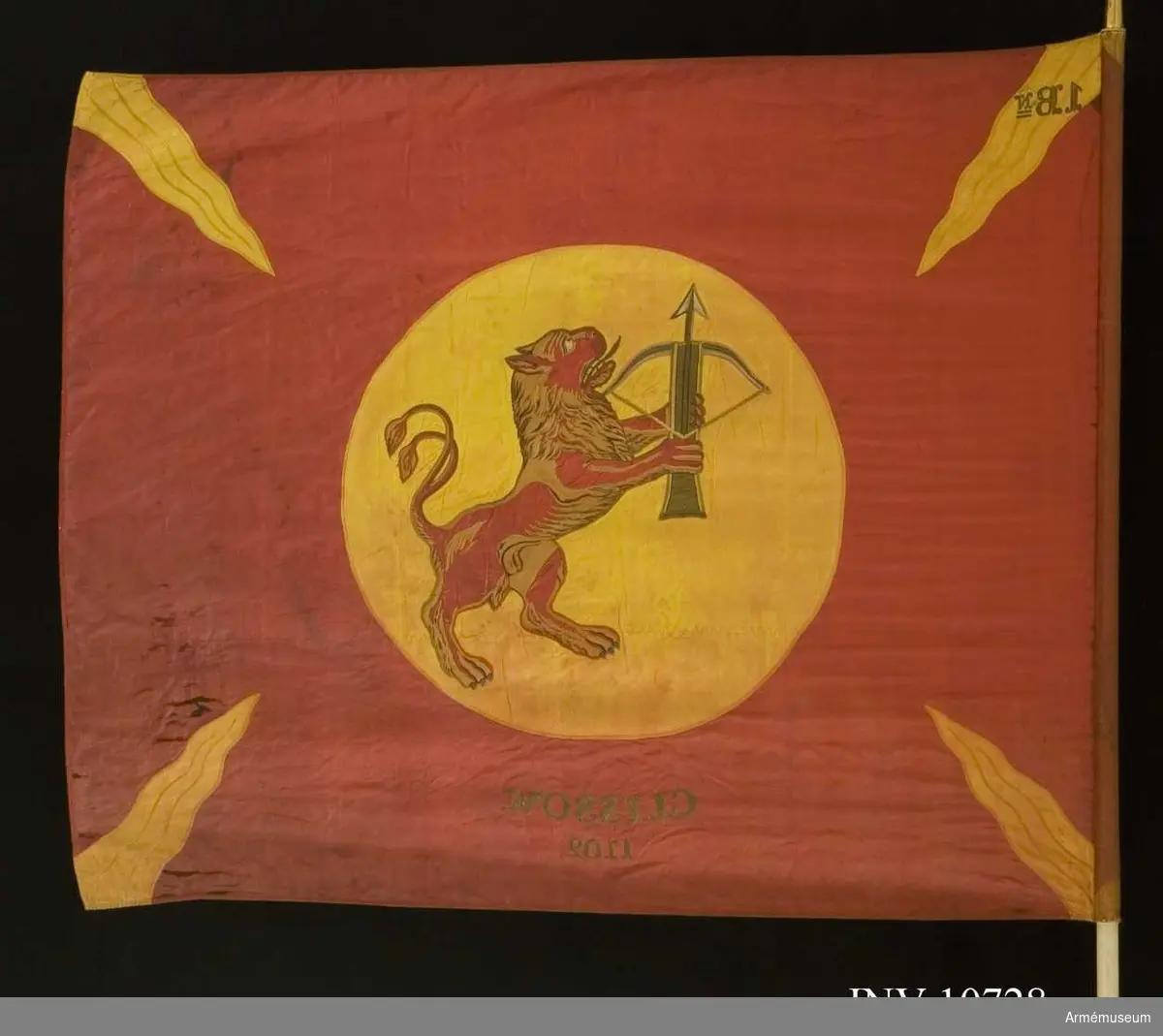 Grupp B.

Duk av rött, fyrskaftat fansiden (kypert), med från hörn och sidornas mitt ingående 4 st flammor av gult liknande siden. I mitten, broderat lika påbåda sidor, Smålands vapen, i gult fält (830 mm) ett rött lejon förande ett spänt armborst med pålagd  pil. Lejonet av rött fansiden med man och skuggning i bruna  och violetta silken, tänder och klor i silver. Armborstens  stock brunt siden, silvertyg i bågen och och pilen, kantsömmar i plattsöm i olika silken. Segernamn under vapnet, genombroderat i guld: Clissow 1702. Kantad med sidenband och fäst med förgyllda spikar. Kravatt: blå och gul av fansiden, med pil och frans. Längd 1920 mm, bredd 290 mm. Stången av furu, målad vit. Doppsko av förgylld mässing. Spetsen av förgylld mässing. Ett fodral tillhör också. Fodralet i svart kläde med skinnskodd spets, dragsko och ficka för spetsens blad. Längd 1840 mm, bredd 180  mm.