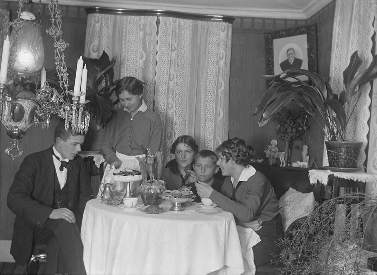 Enligt senare noteringar: "Ingrid Olsson, John, Ester och Ingrid Helgesson, Ego vid kaffebordet 3/2 1916."