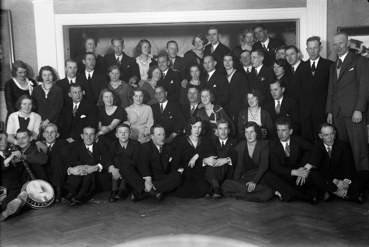 En gruppbild på män och kvinnor i en samlingslokal.