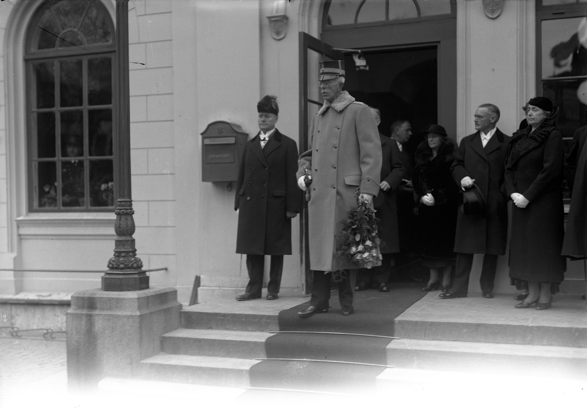 Kung Gustav V på trappan till Centralstationen i Jönköping med rosor i handen.