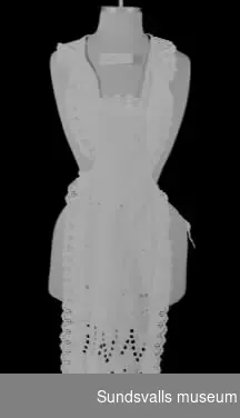 Förkläde i vitt, nästan transparent, bomullstyg med vitbroderi. Knytband i midja och runt halsen. Förklädet har givaren fått efter sin svärmor, Agnes Erixon (f. 1889 i Bureå, d. 1966), maka till disponenten vid Vivstavarv, E J Erixon.