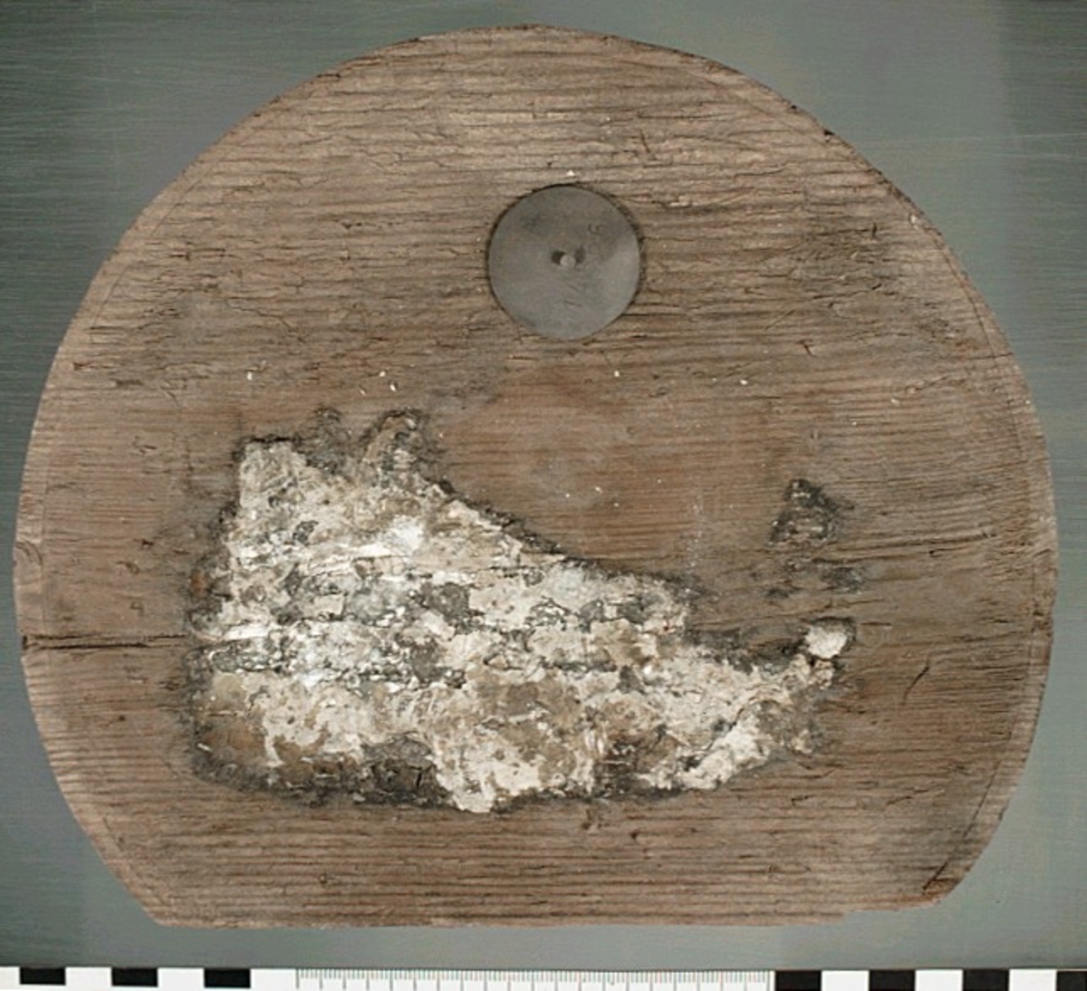 Botten till en bytta eller liten tunna. En del saknas. På föremålet finns vita klumpar som efter analys visats sig vara troliga rester av smör.