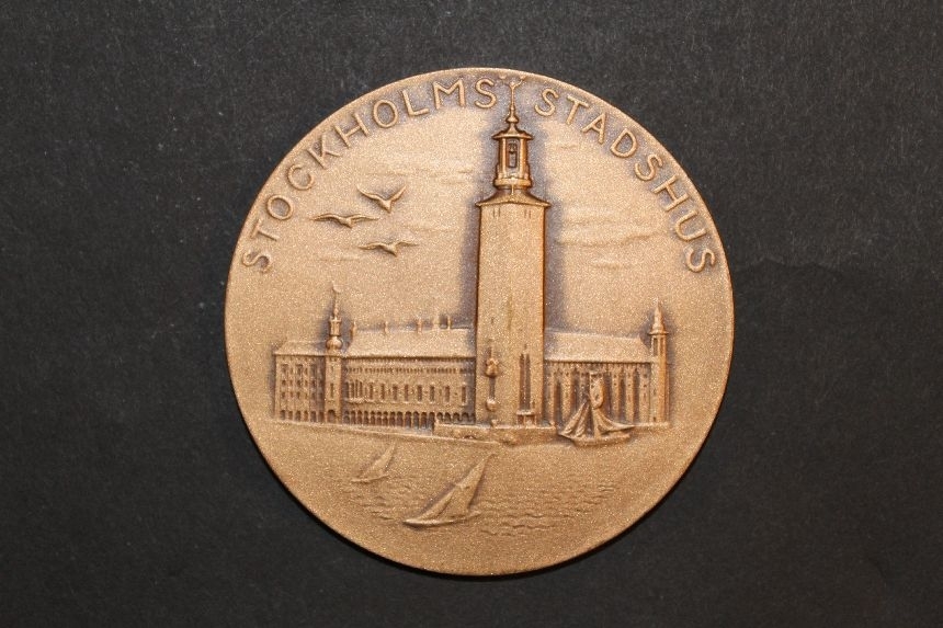 Medalj i brons med motiv av Stockholms stadshus på åtsidan.
På frånsidan, text: Internationell Frimärksutställning, Stockholmia
74, 21/9-29/9 1974, SVENSSON