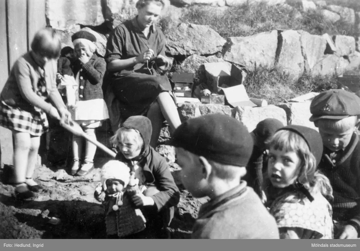 Bosgårdens barnträdgård 1938-1945. Förskollärare och barn som leker utomhus.