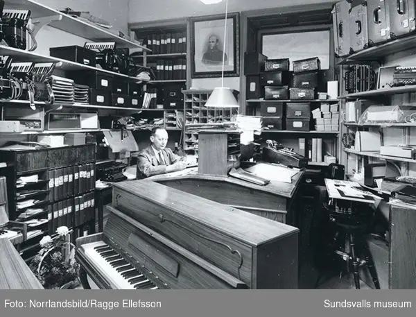 En svit bilder från Joel Sjöbergs musikhandel vid Stora torget. På bild nr 1 och 8 ses Joel Sjöberg själv. Affären grundades av hans far Johan Petter Sjöberg 1876 och dagen innan Joel Sjöbergs 97-årsdag såldes verksamheten till Curt Thylin.