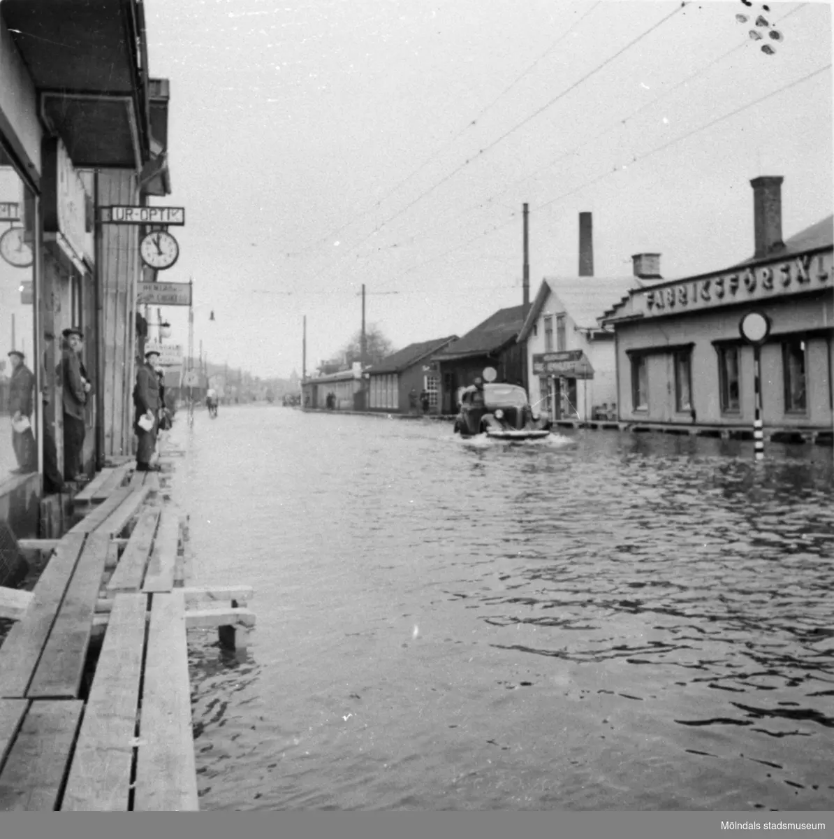 Kl 11.00 på förmiddagen. Översvämning på Göteborgsvägen vid biografen Grand i Mölndalsbro, omkring 1940.