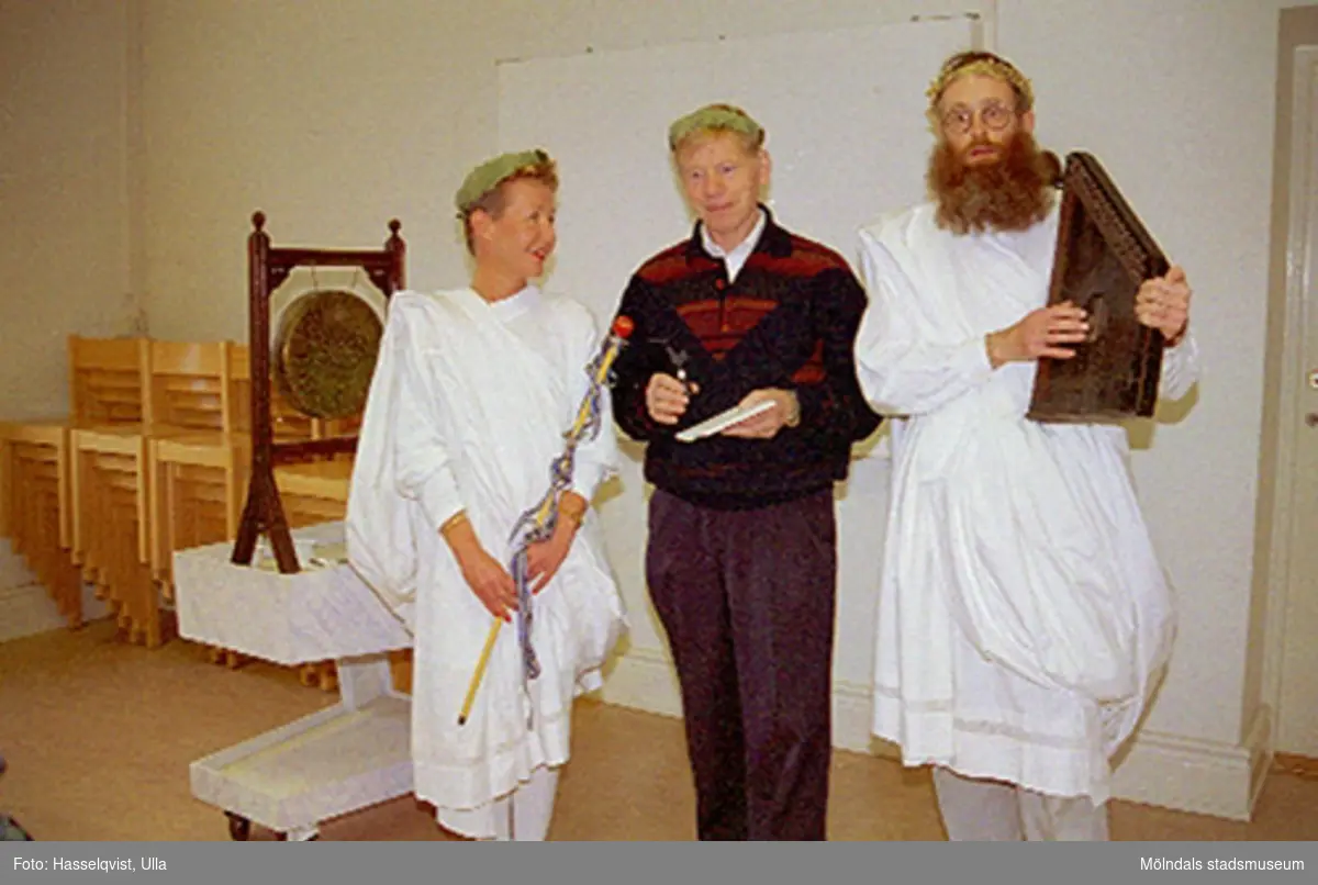 Avtackning av intendent Sten Svensson på Mölndals museum 1994. Personerna klädda i lagerkrans och toga är Pia Persson och Lars Gahrn.