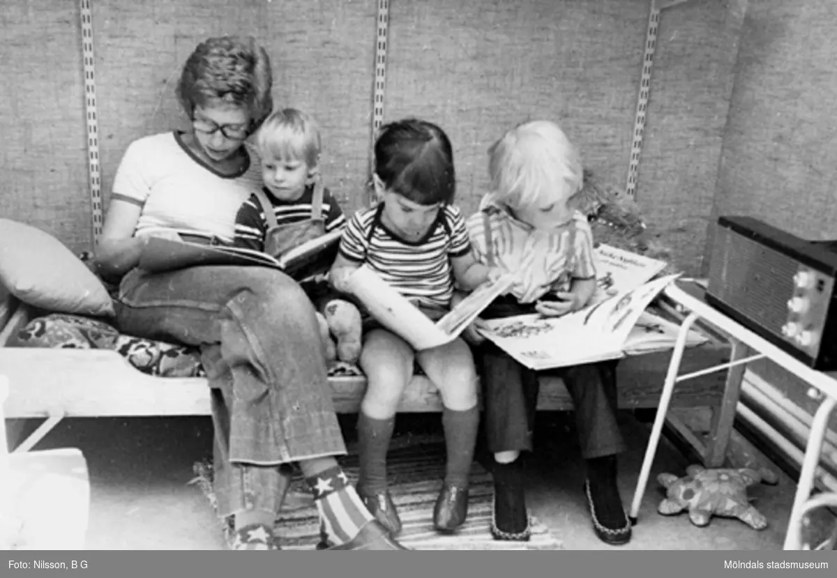 En fröken som läser för ett barn och två andra som tittar i böcker. Holtermanska daghemmet, okänt årtal.