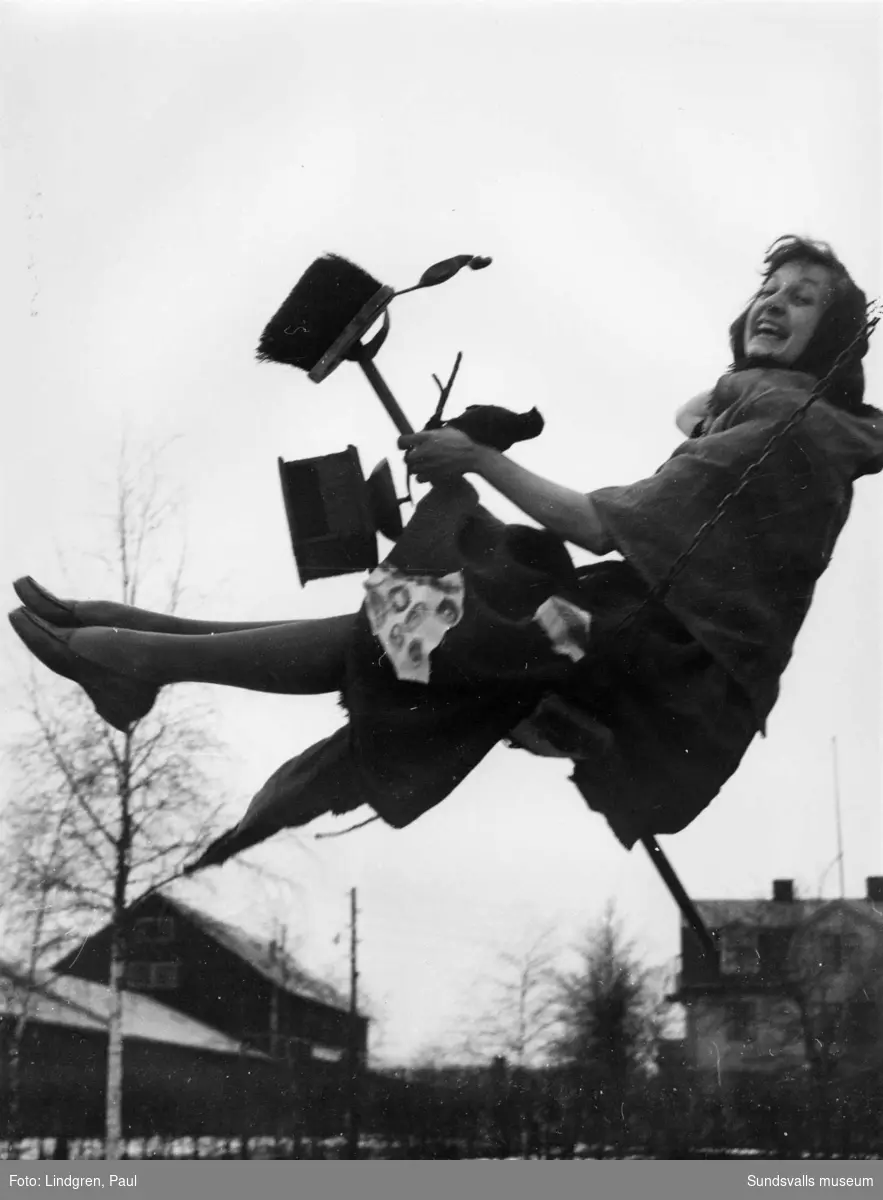 Ulla Wennersten agerar Blåkullafarare i ett skämtsamt reportage i Sundsvallsposten 1957. Hon startade sin flygtur från en gunga i lekparken vid Västra stationen.