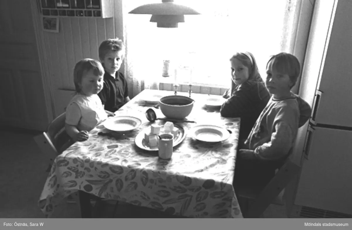 Fyra barn som sitter runt middagsbordet, 1980-tal.