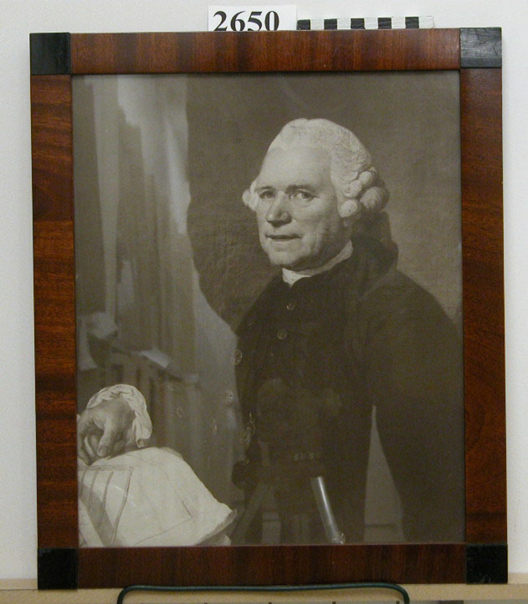 Fotografi av porträtt av byggmästaren Daniel Thunberg, inramad i brun ram med glas.