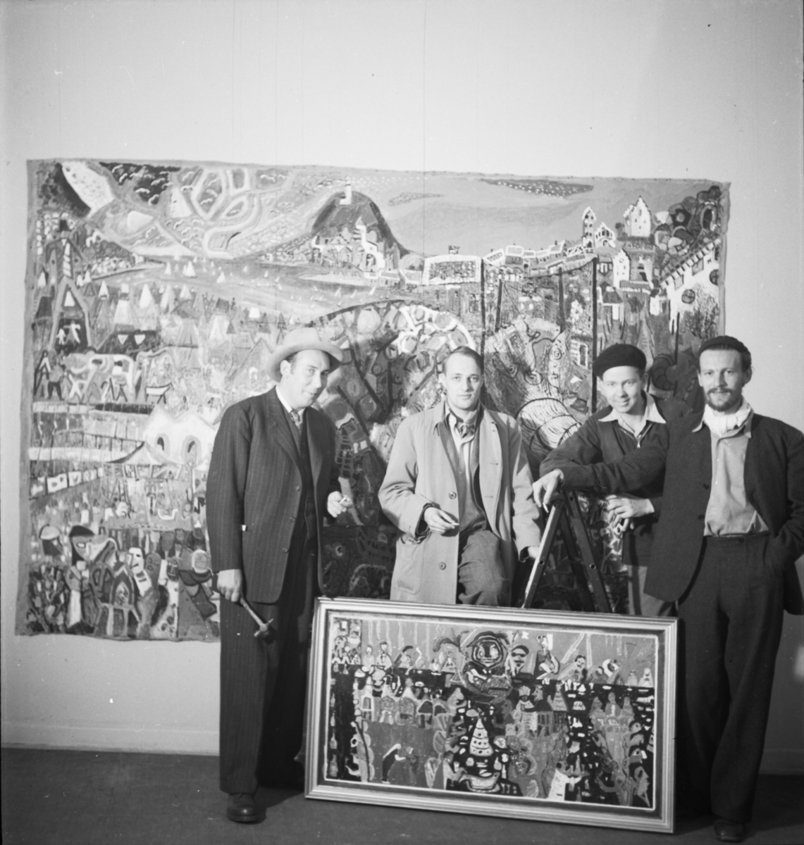 Två tavlor av Uno Vallman och i förgrunden fyra män