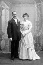 Studioportrett av et brudepar i helfigur.