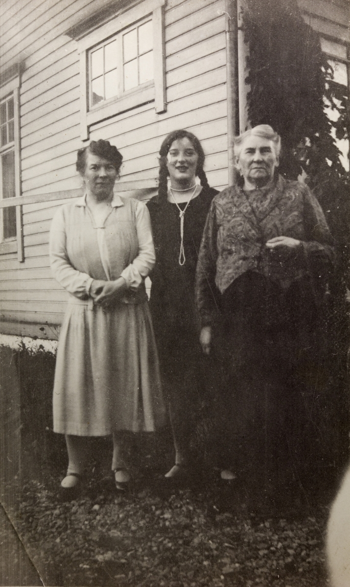 Tre kvinner foran hus - Klara Sogge (gift Iversen) i midten, flankert av mor og bestemor.