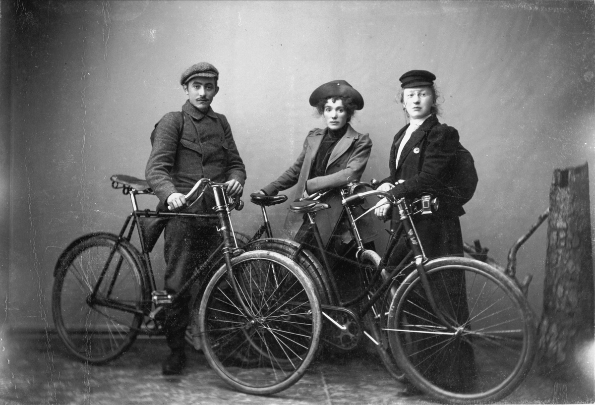 Studioportrett av tre personer med sykler.