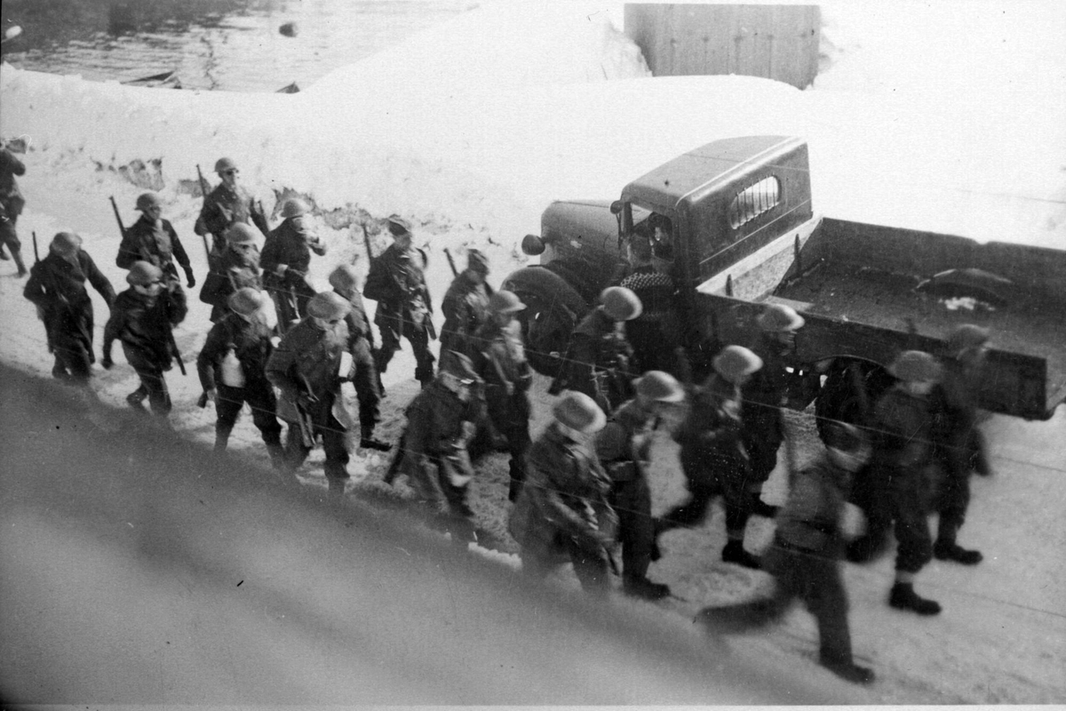 Britiske soldater marsjerer forbi en lastebil i Havnegata.