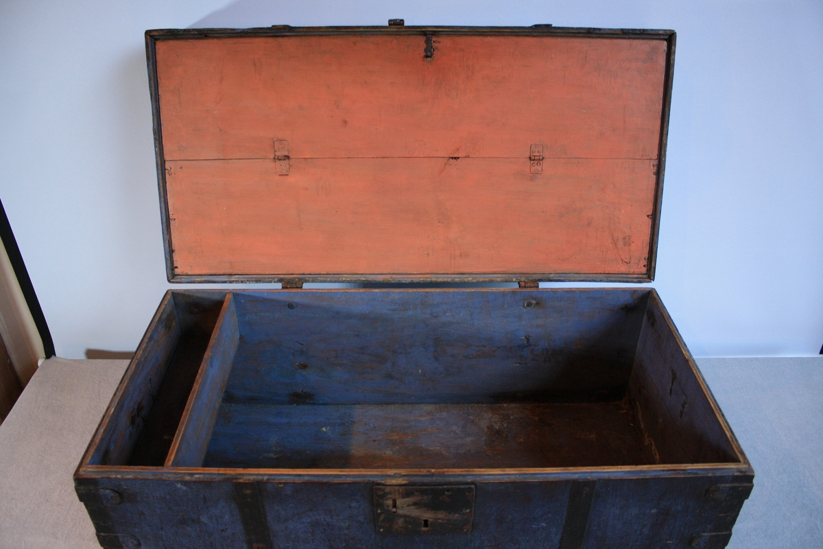 Gråblå kiste med bua lok og metallbeslag. Har ein leddik utan lok. Hengsla bunn av loket som gir eit oppbevaringsrom (målt oransje). Kjem frå rom 2 i Ausevika.