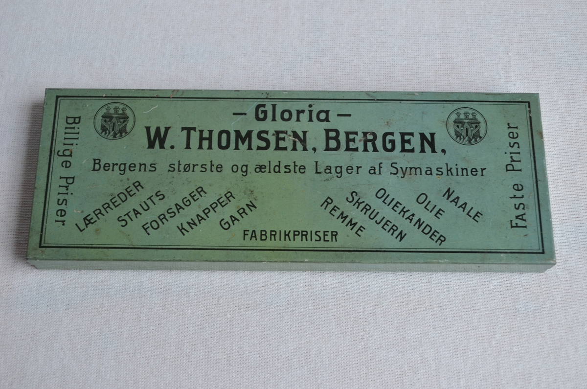 Grøn blikkboks i frå familiebedrifta W. Thomsen. Den har truleg inneholdt tilbehør til symaskiner.