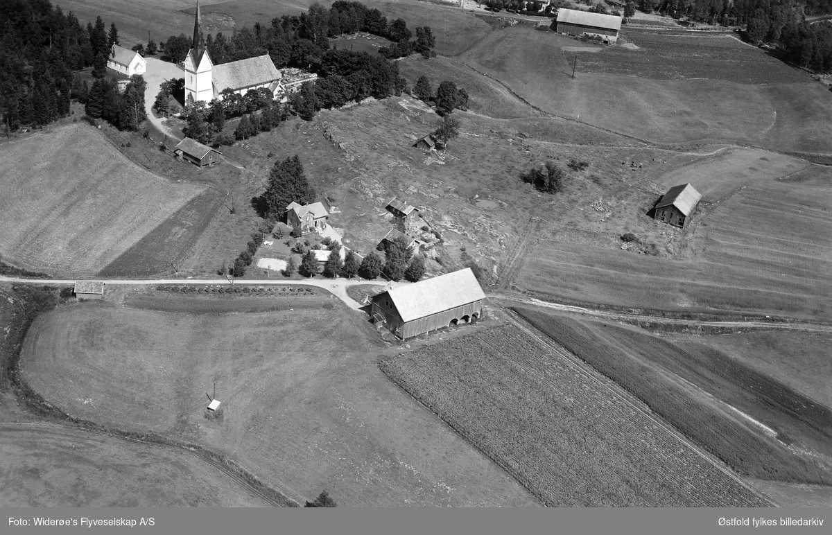 Gården Revhaug i Eidsberg, flyfoto 4. august  1951. Hærland kirke i bakgrunnen.