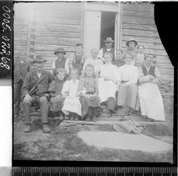 Gruppebilde av fire menn, syv kvinner og fire barn ved et in