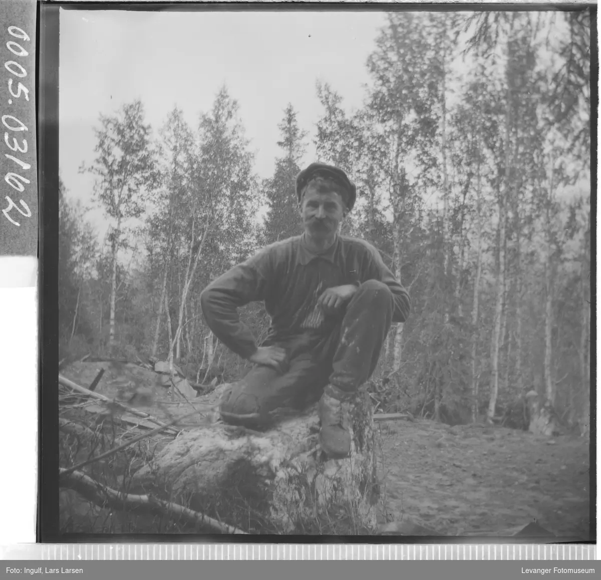 Portrett av en mann som sitter på en trerot.