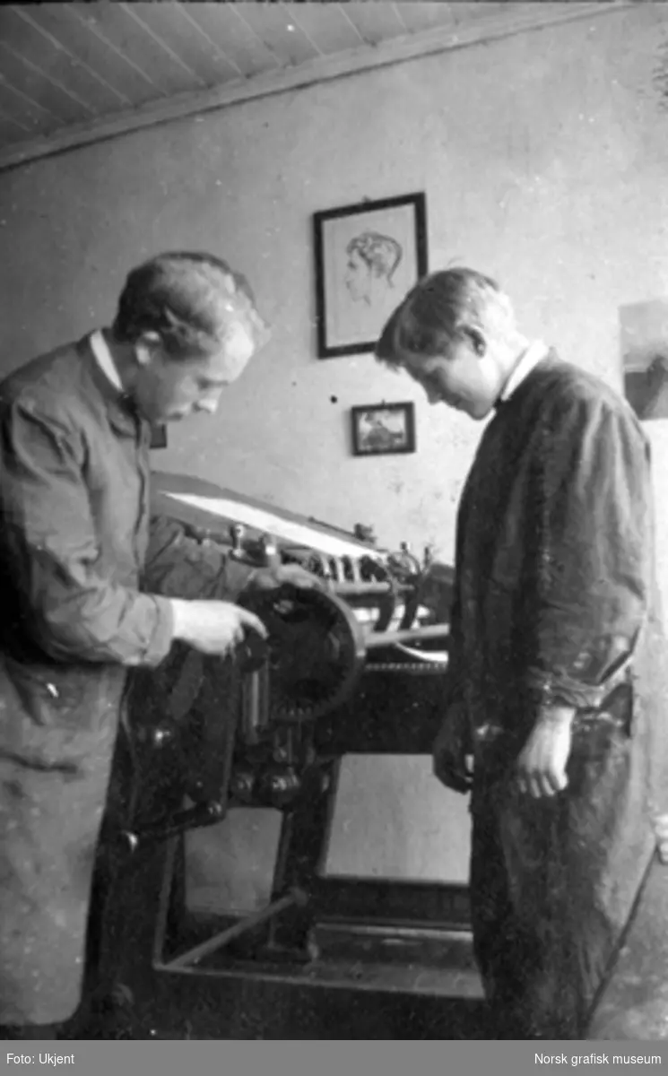 To menn i frakk jobber med en maskin.

Albumtekst:
"Time i maskinpusning. Der maa du og pussa!"