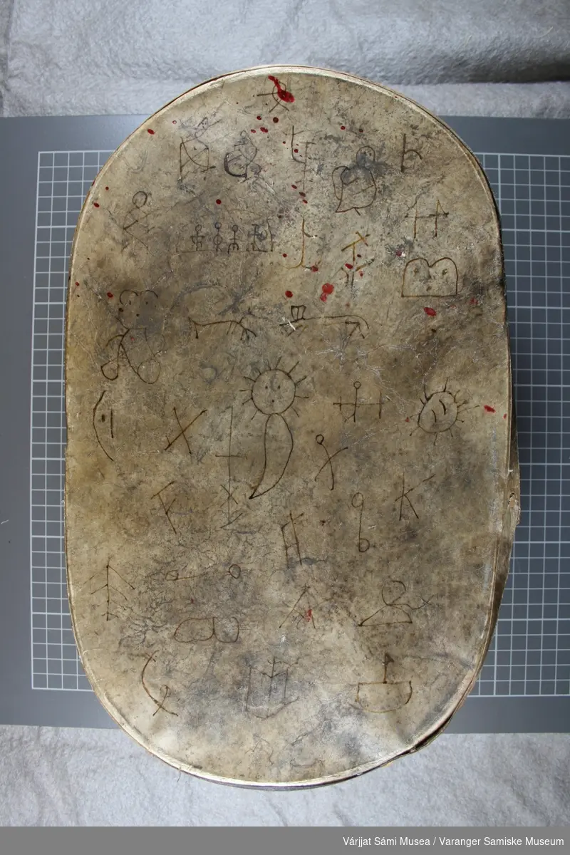 Moderne replika av runebomme/sjamantromme. Den er laget av tre og skinn, skinnet er dekorert med ulike figurer.