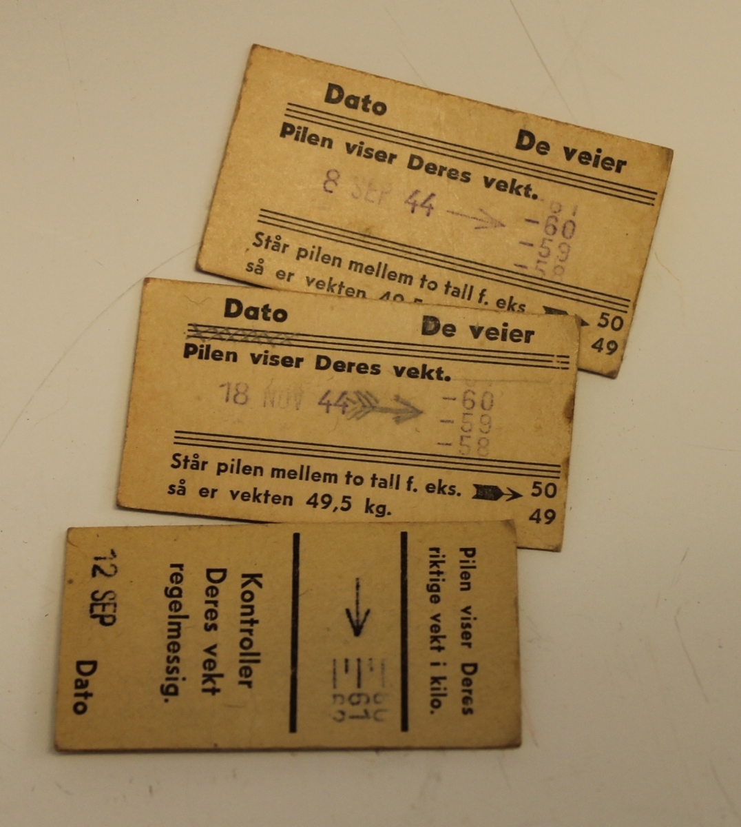 Rektangulær lommebok med to rom og ei lomme med lokk. Trykknapp lås. Maskinsydd. Oppi ligger ei nål, tre vektbonger fra 1944 og en kinobillett  til Askin kinoteater.
Bonger har et dikt på baksiden.