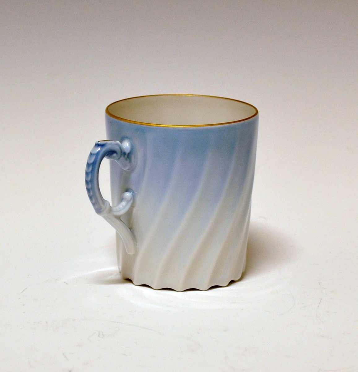 Kaffekopp i porselen. Dekorert i lyseblått og med gullkanter.
Dekor Maud, i produksjon fra 1978-2006.
Modell Bogstad.